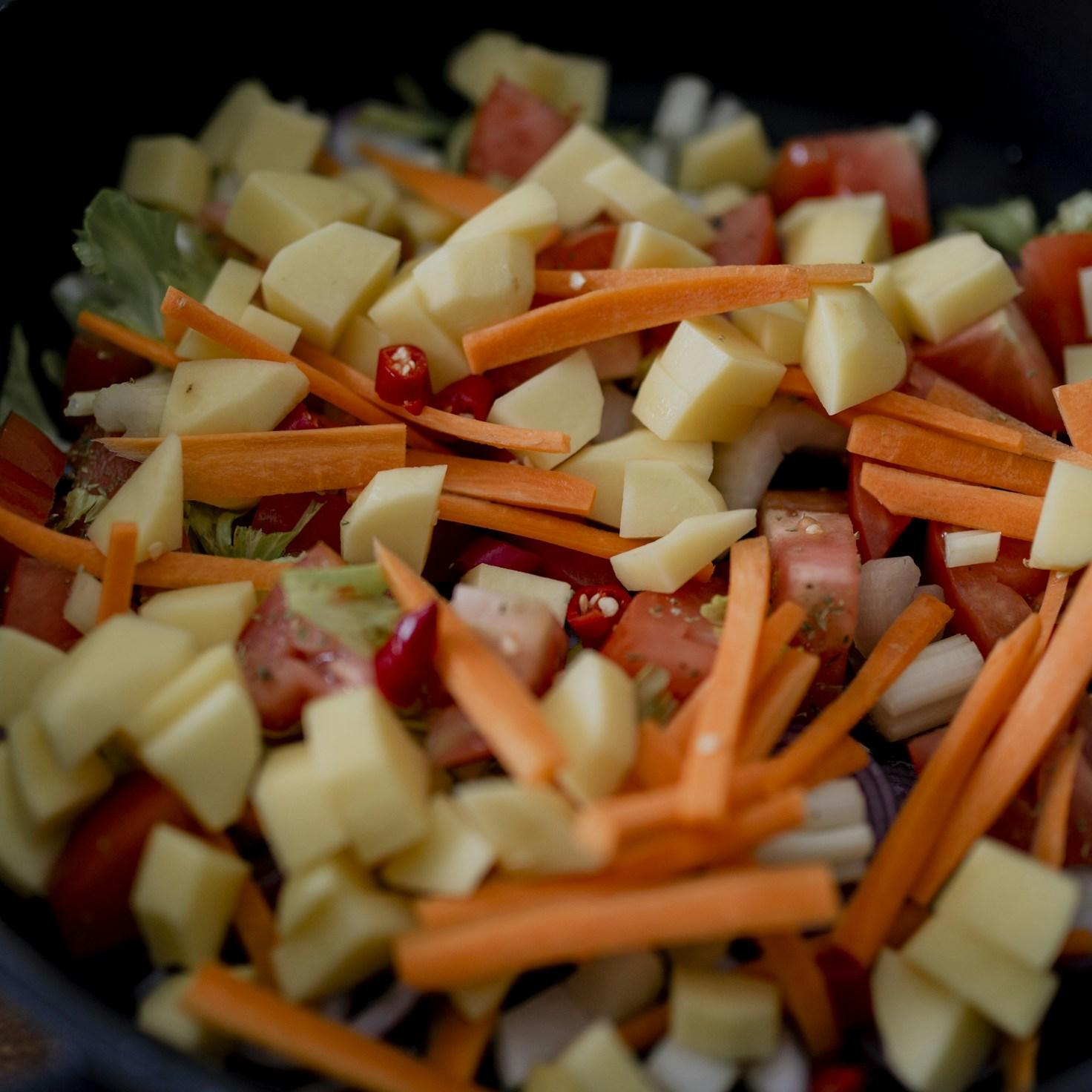 Diverse group of community members sharing a meal together, showcasing the social bonds formed through collaborative cooking